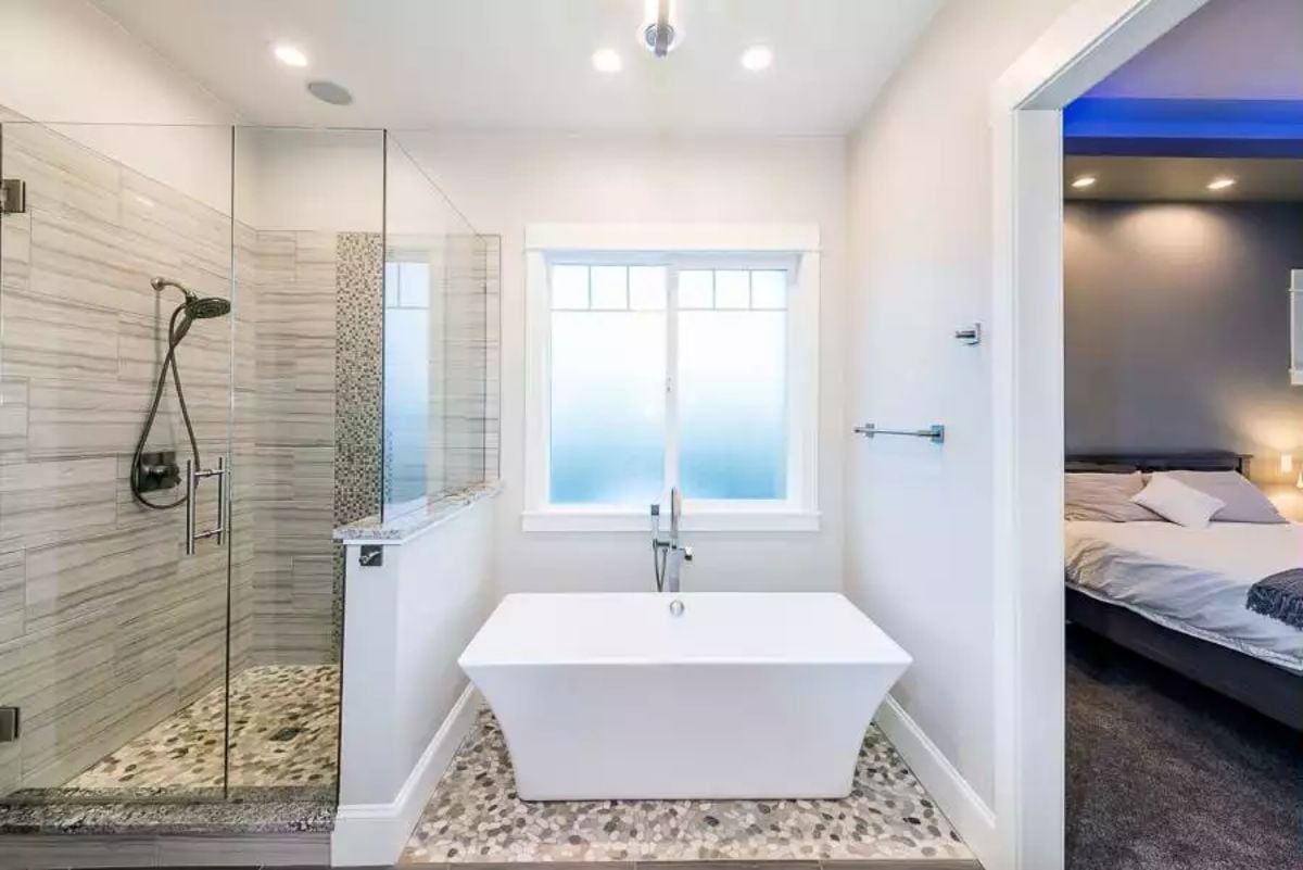 Freestanding Soaker Tub Centered on Frosted Glass That Earns Its Own Wall