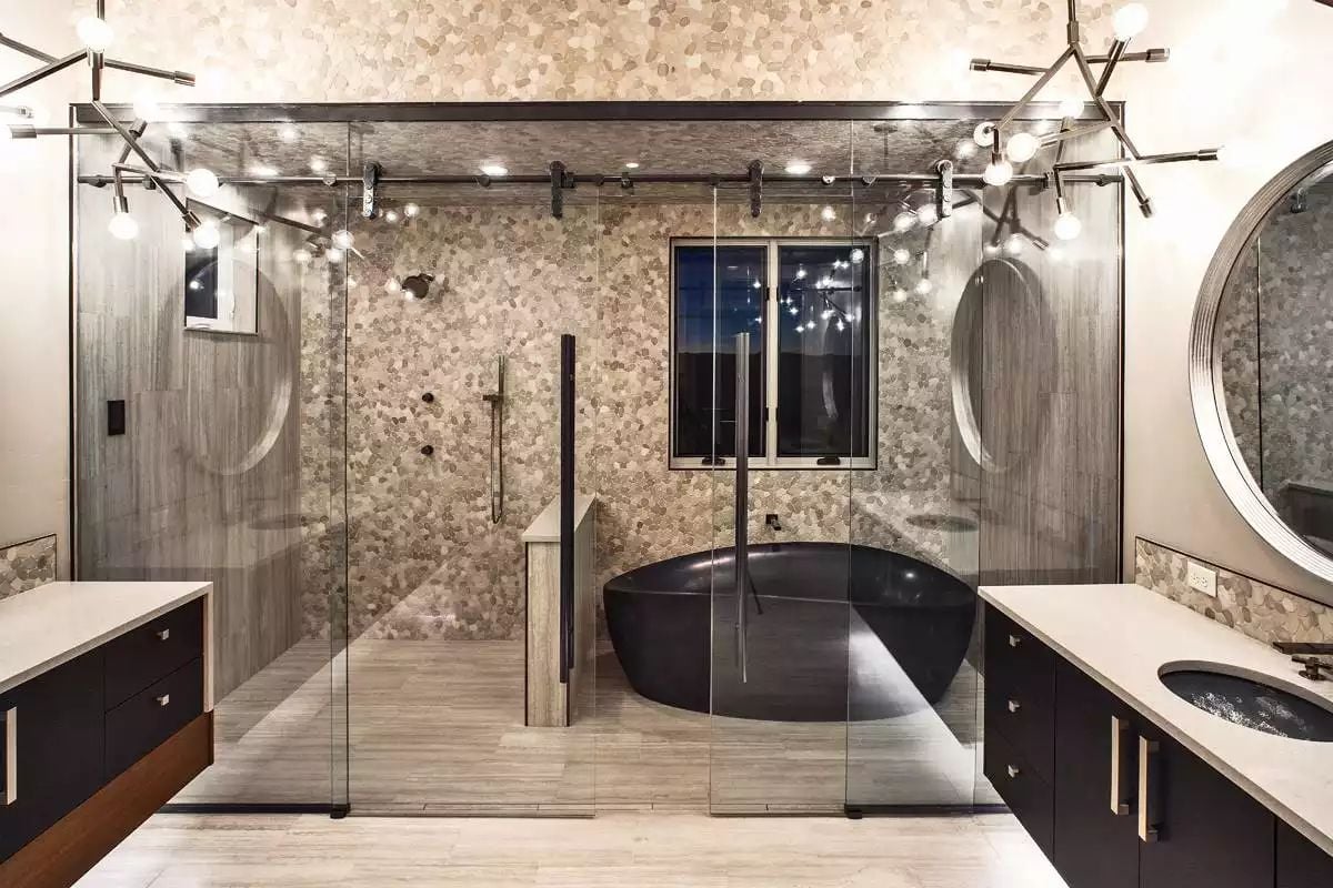 Pebble Tile Walls and a Black Soaking Tub Inside Glass Barn Doors Worth the Splurge