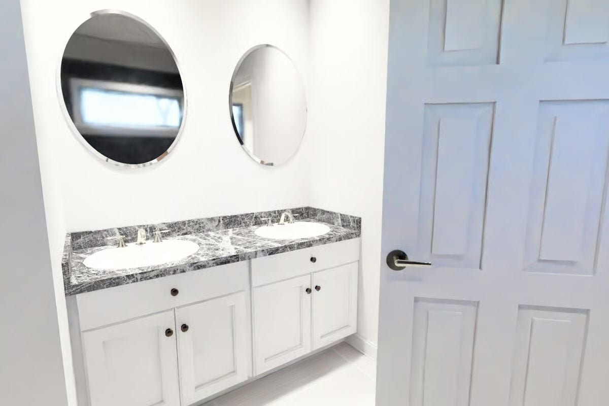 Double Sinks, Dark Marble, and Round Mirrors That Don't Try Too Hard