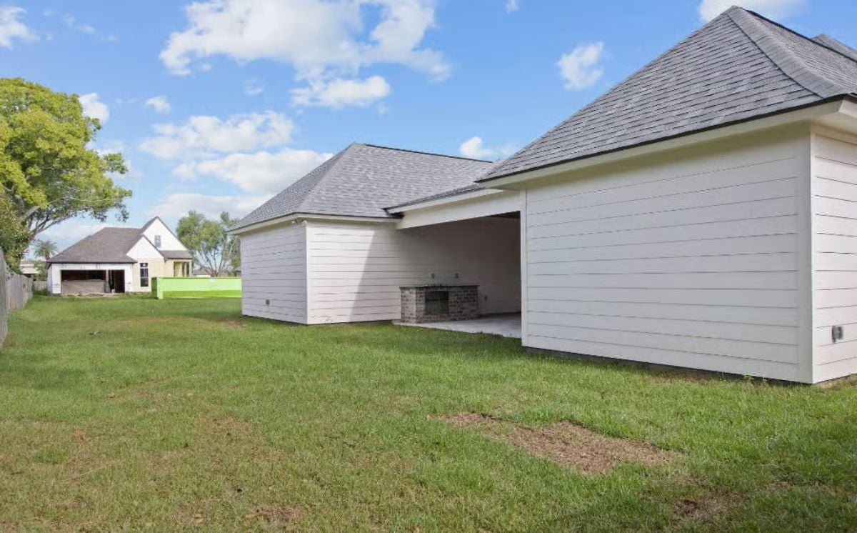 Covered Rear Porch With Brick Fireplace Built for Year-Round Backyard Living