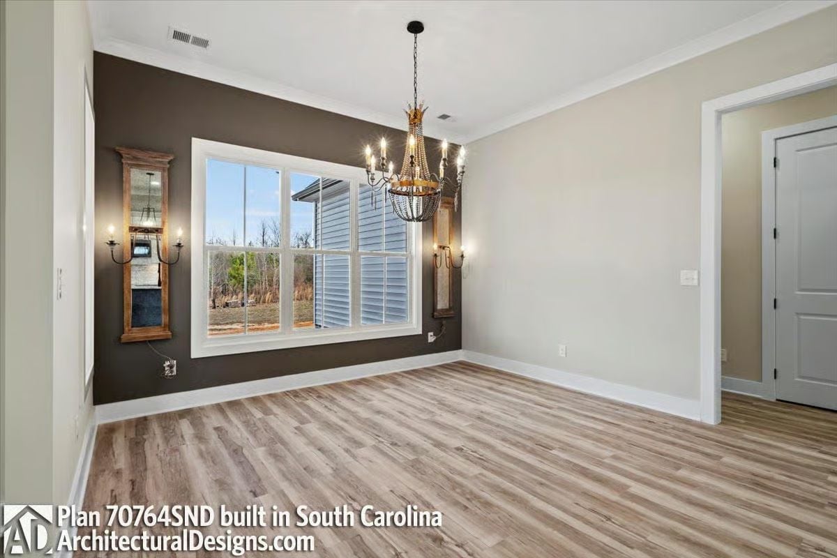 Dark Accent Wall Behind a Chandelier Earns Its Place in an Empty Room