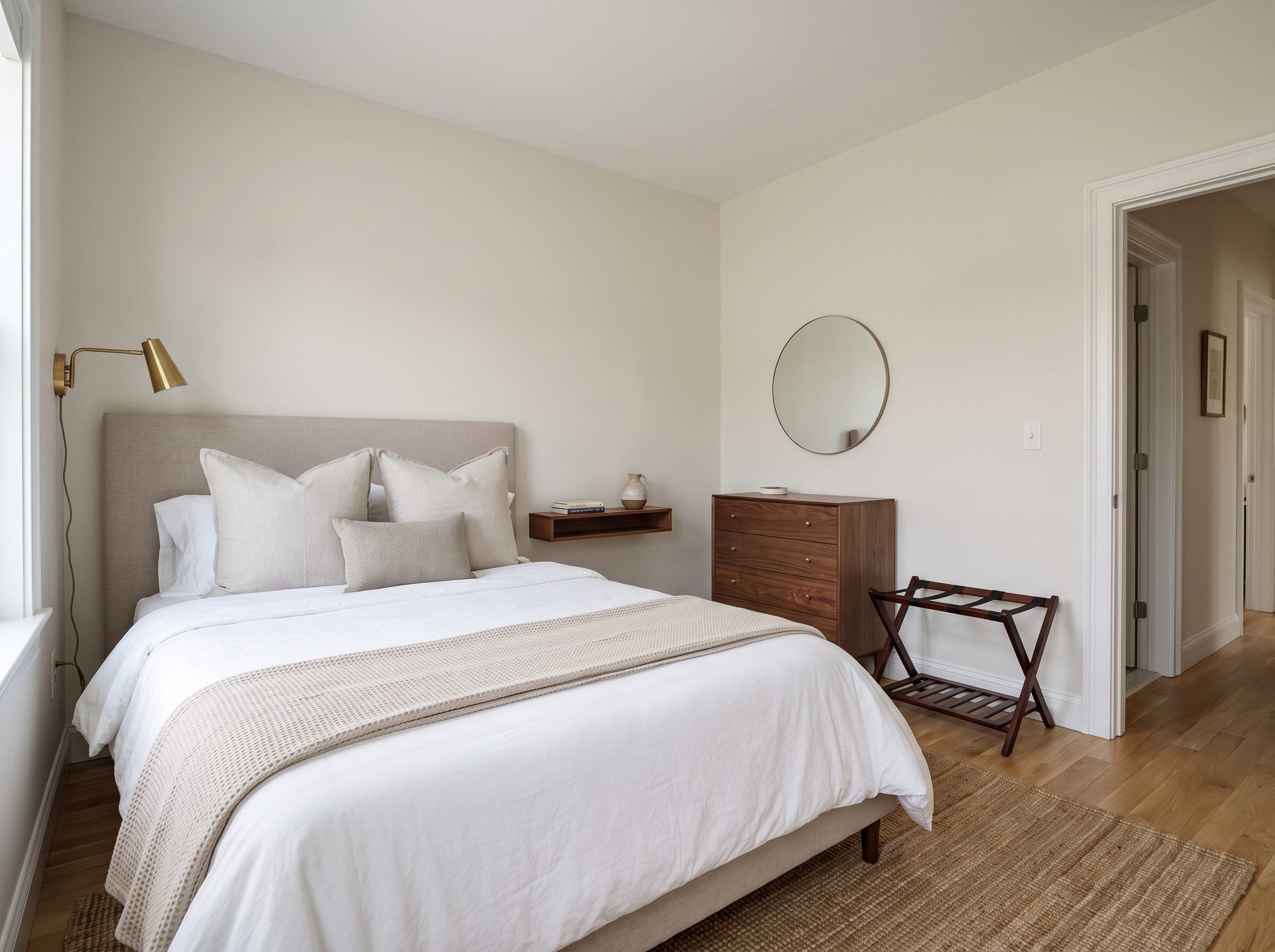Eight-by-nine guest room with a full bed against the long wall, a 30-inch path on the open side, and a dresser and luggage