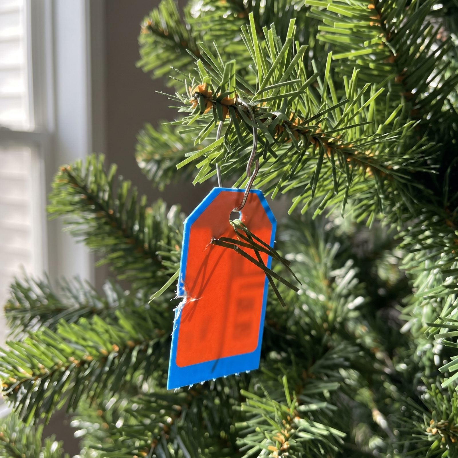 Artificial tree trunk joint with small red, blue, green, and yellow color-coded assembly tags visible between the branches.