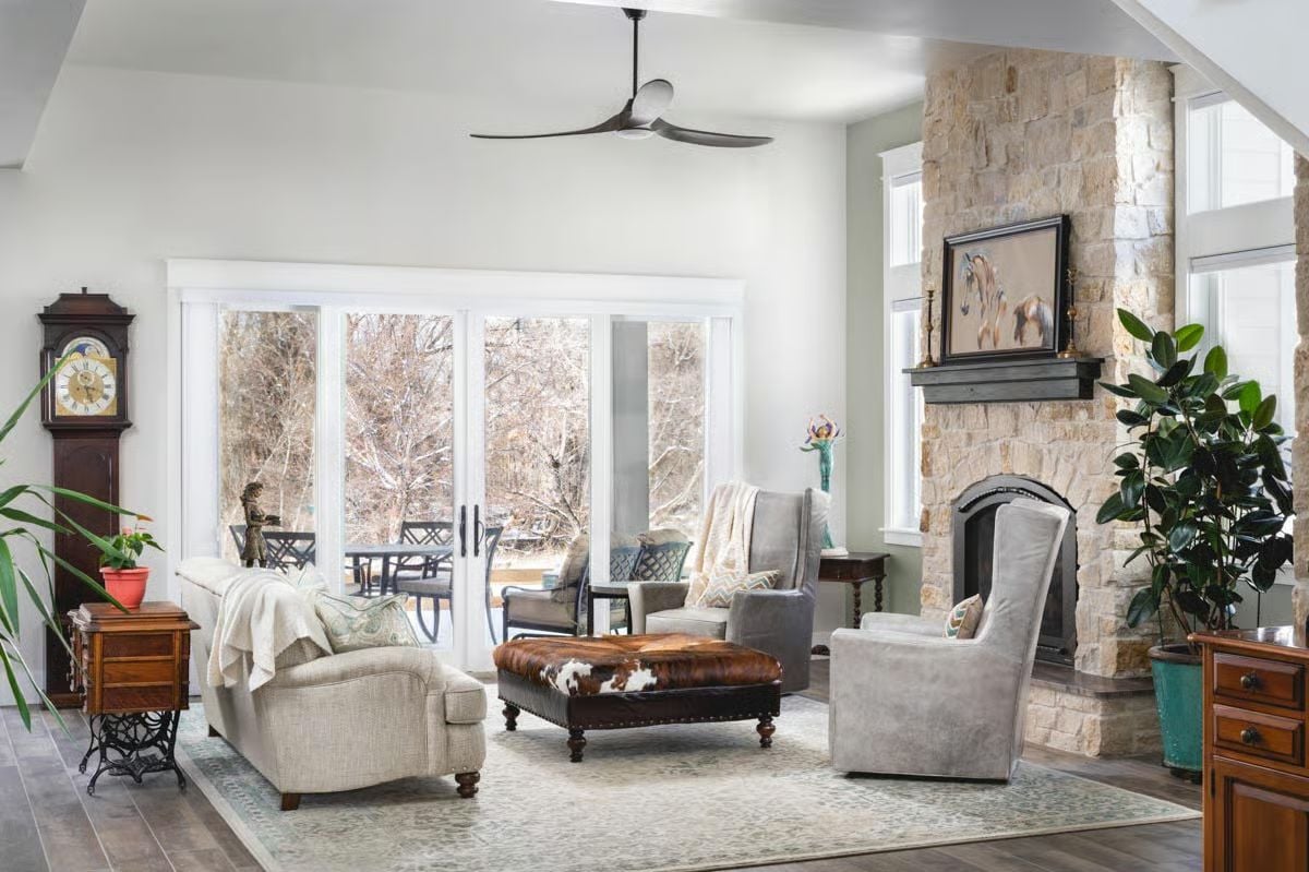 Cowhide Ottoman and Stone Fireplace Pull Two Design Worlds Into One Room