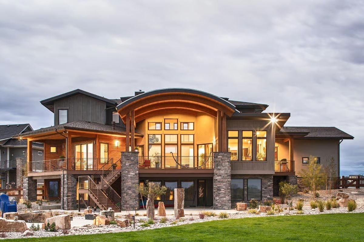 Curved Timber Barrel Vault Owns the Rear Facade at Dusk