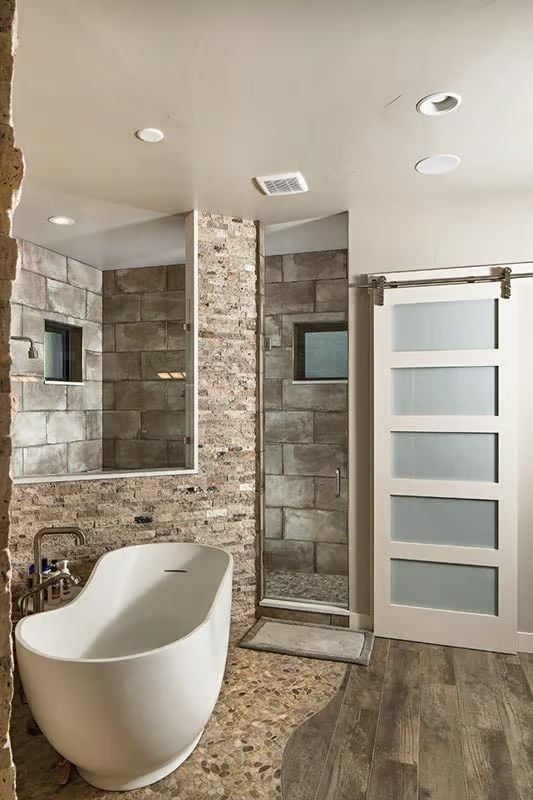 Freestanding Soaker Tub Against Stacked Stone Pulls Off Two Moods at Once