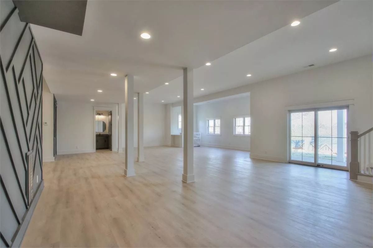 Light Wood Floors and a Geometric Fireplace Wall Doing the Heavy Lifting