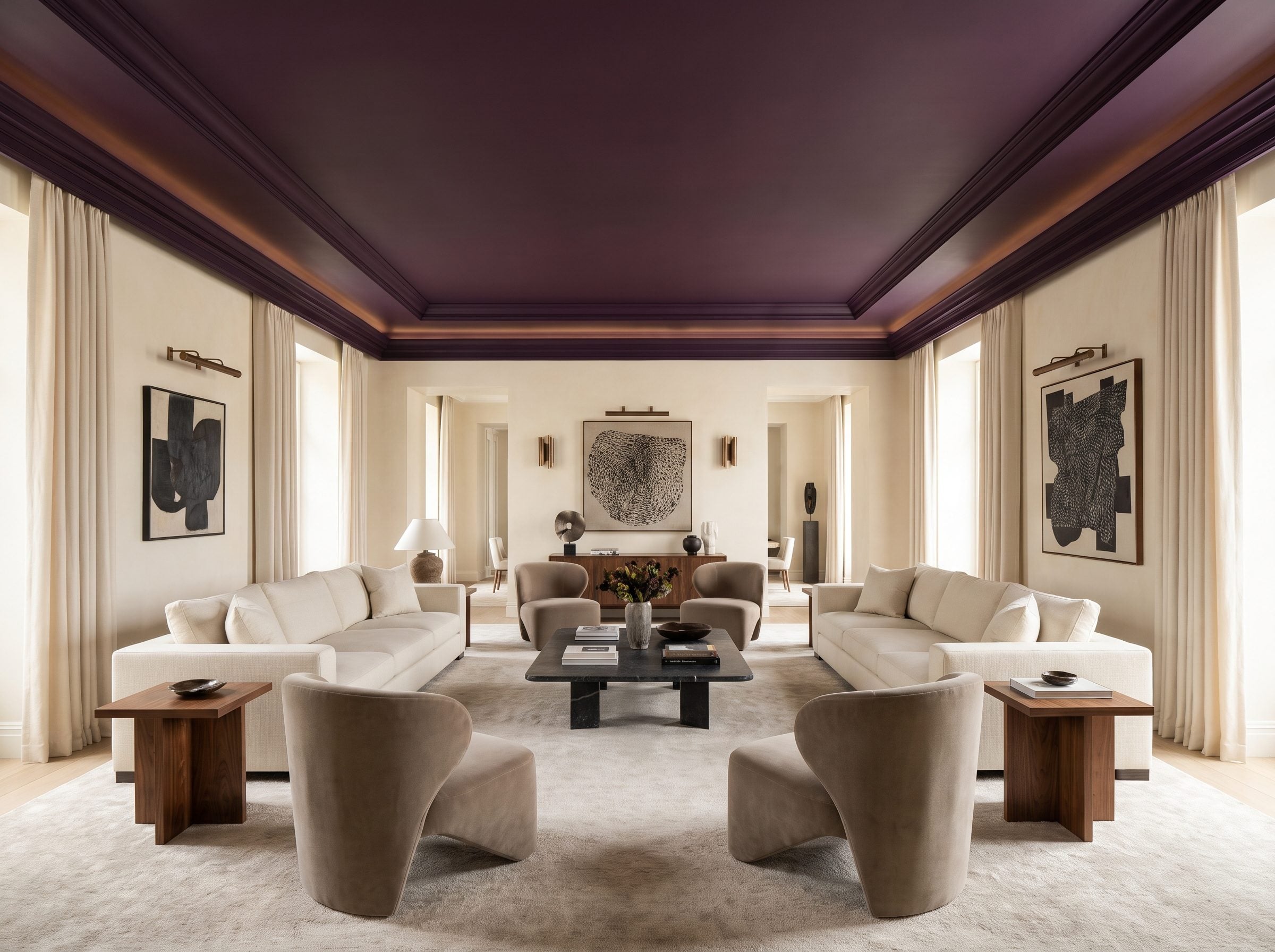 Living room with a deep aubergine-painted ceiling above ivory plaster walls, two cream sofas, and a neutral wool rug.