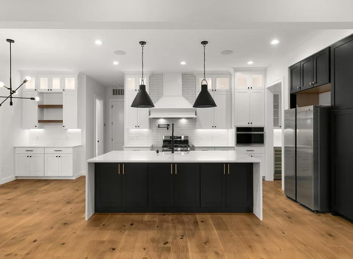 Black Island Base Against White Cabinetry Pulls This Kitchen Into Focus