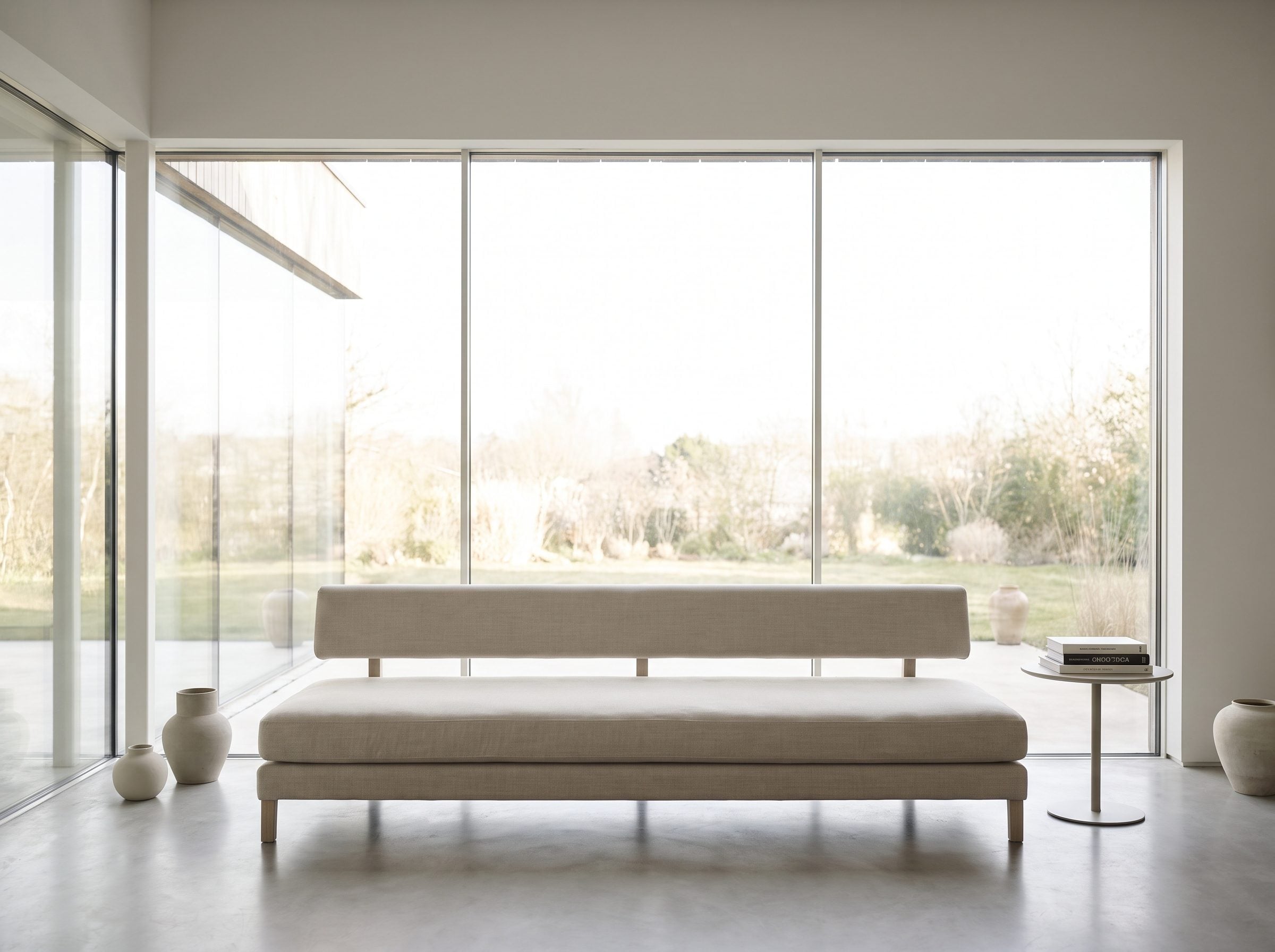Living room with a backless daybed under a window, its cushion top sitting about eight inches below the sill so the full