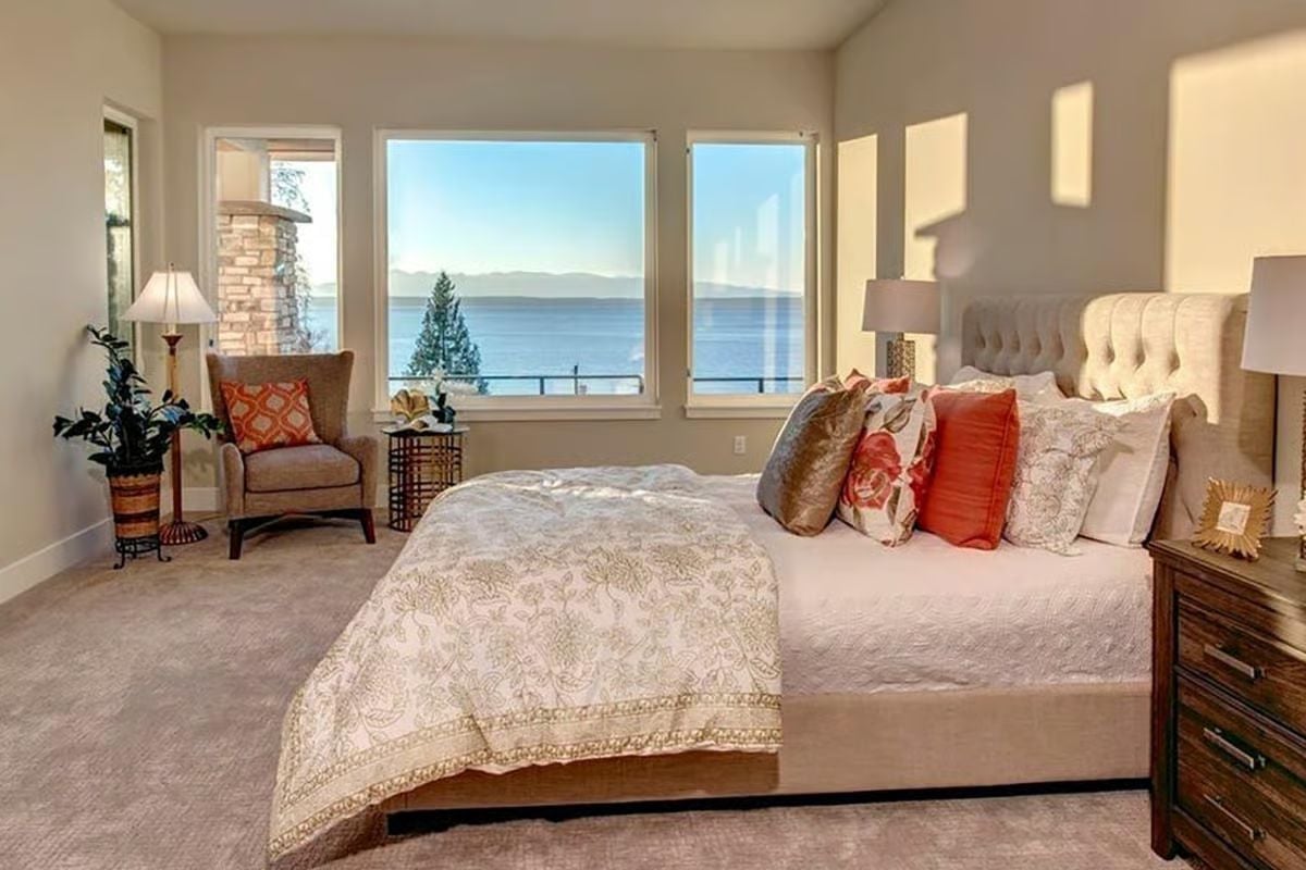 Coral Pillows, a Tufted Headboard, and Water That Fills Three Windows