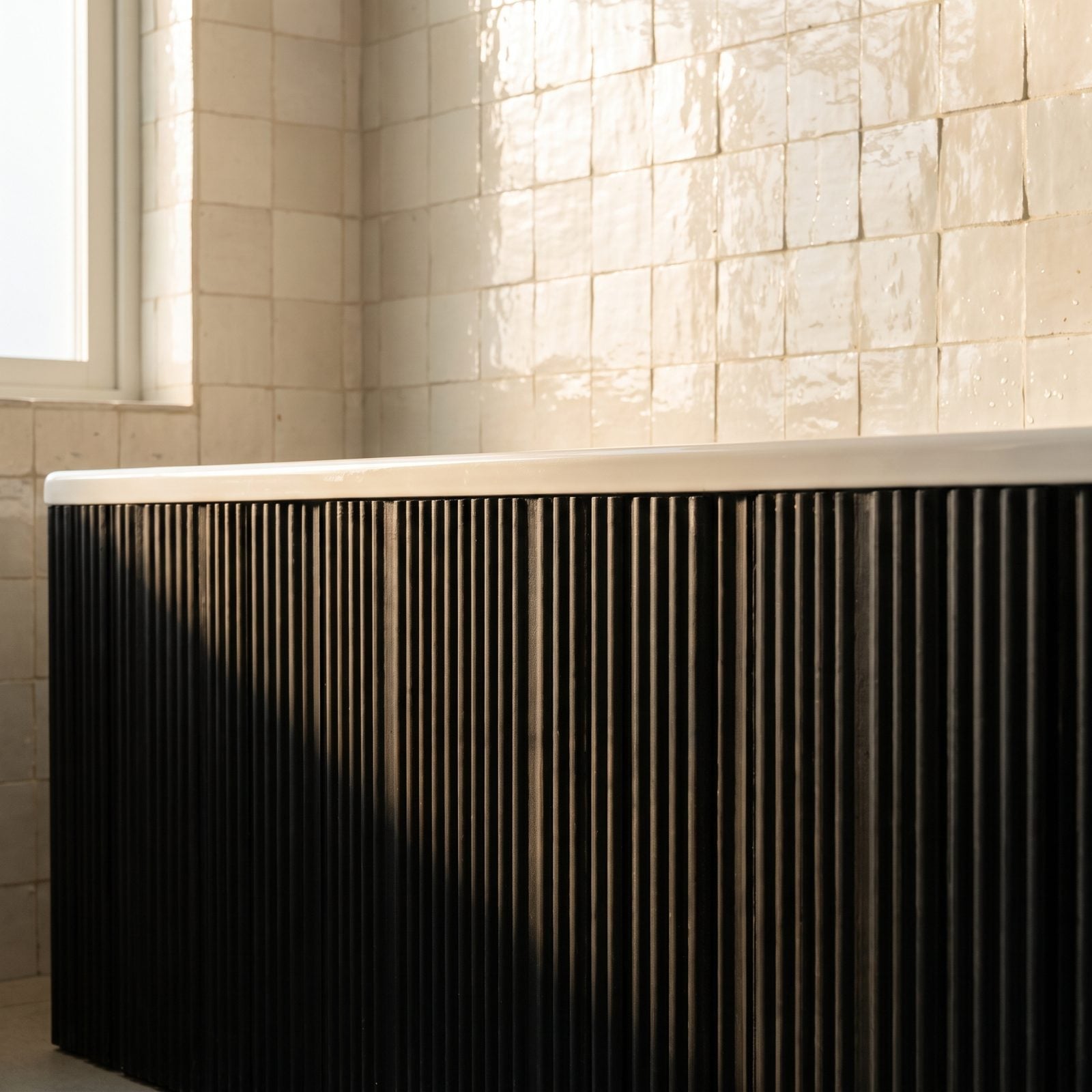 Black Ribbed Tub Apron Surrounded by Cream Tile