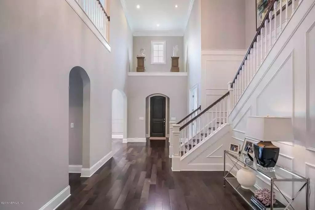 Double-Height Foyer Where Dark Hardwood and White Millwork Do the Heavy Lifting