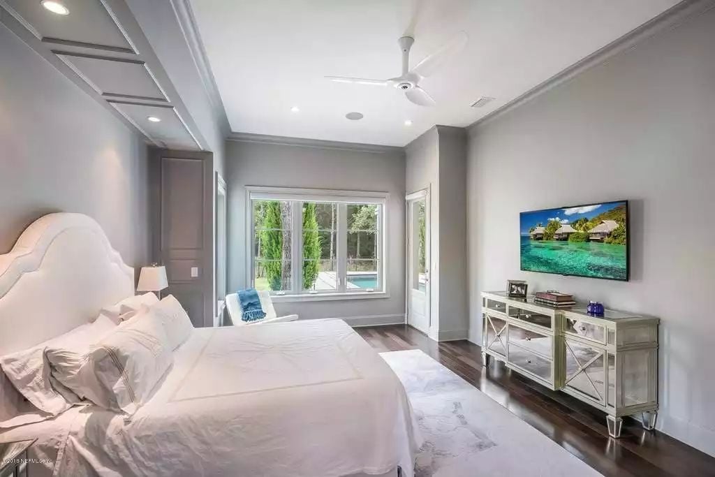 Mirrored Dresser, Wall-Mounted TV, and a Window That Frames the Pool