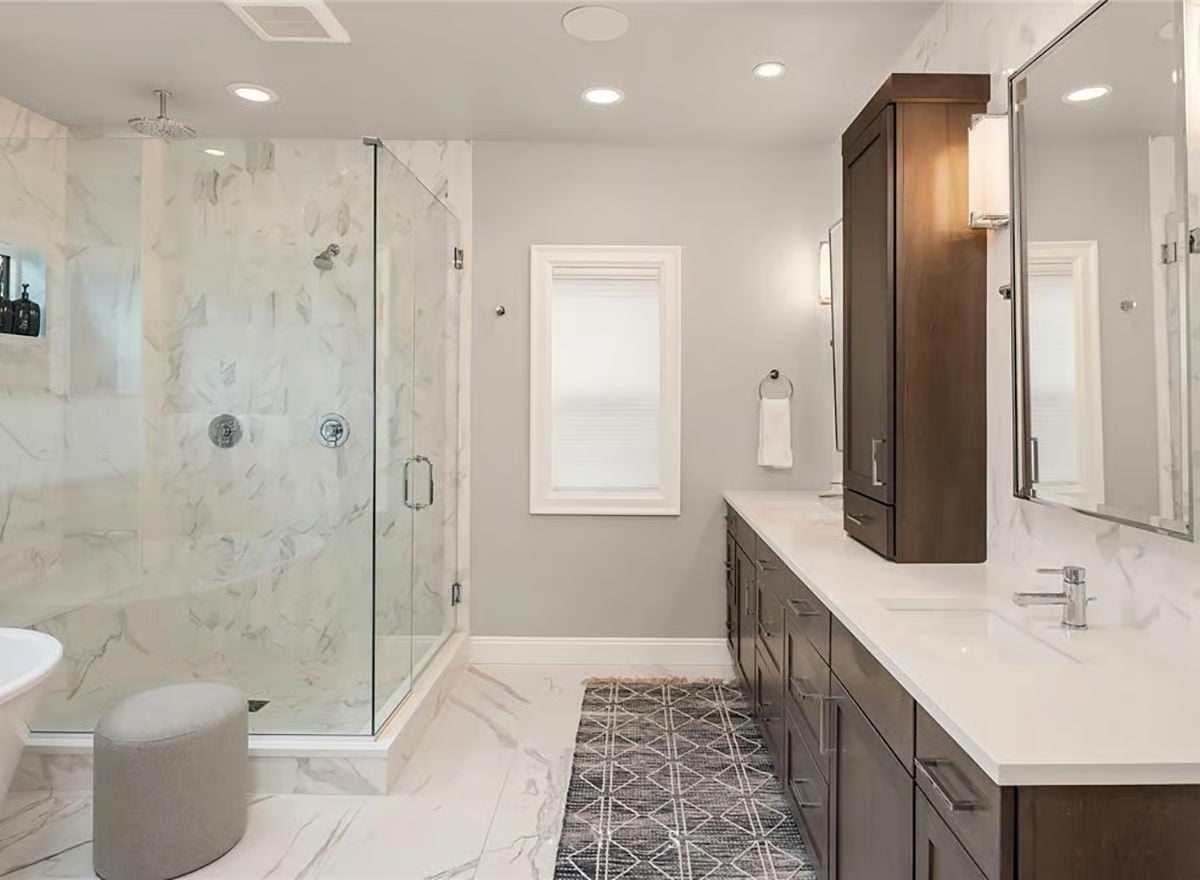 Marble Shower Walls, Dark Cabinetry, and a Rain Head Worth the Ceiling Chase