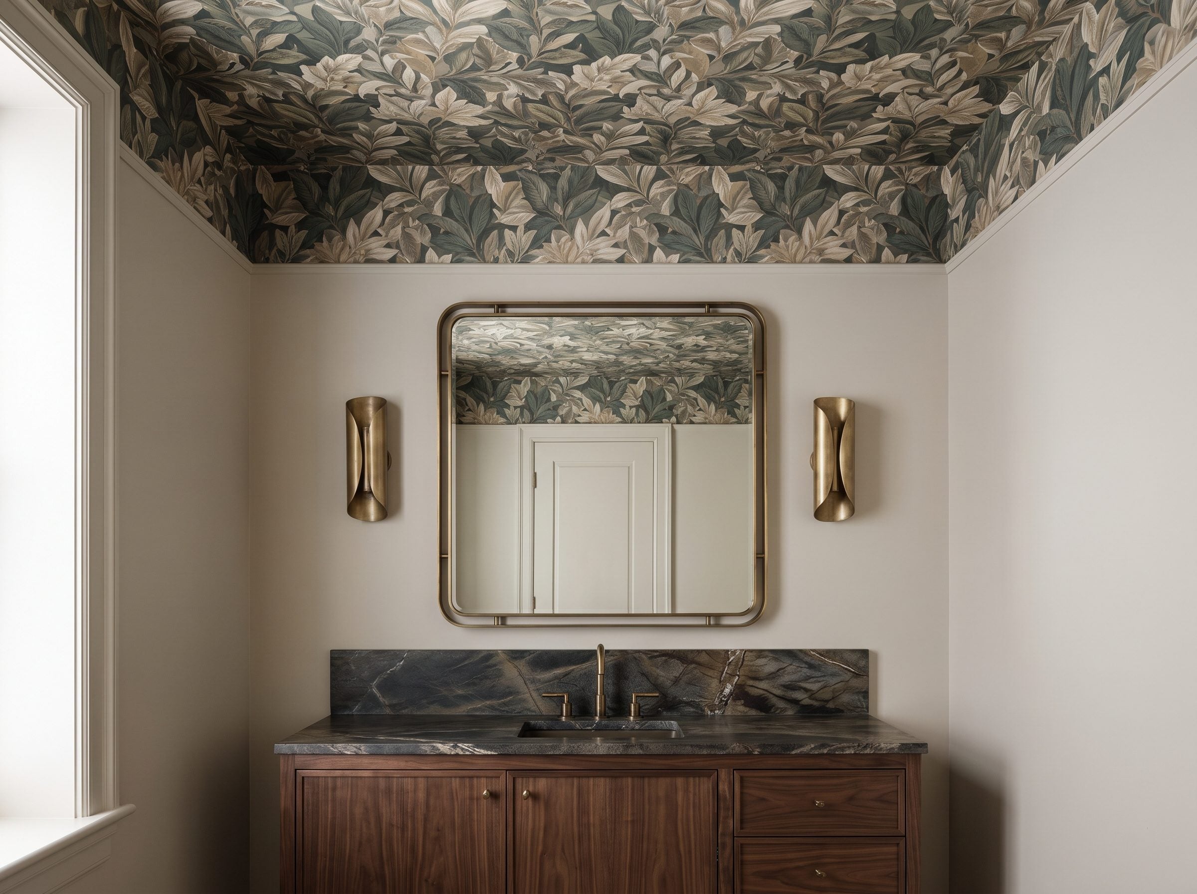 Powder room with botanical wallpaper covering the full ceiling above a walnut vanity, stone counter, and two brass sconces.