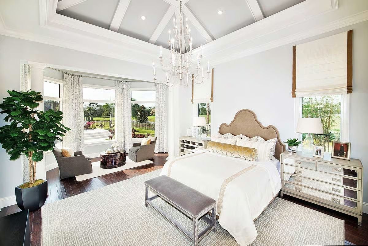 Candle-Style Chandelier and a Cathedral Ceiling Make This Bedroom Feel Like It Has No Ceiling At All