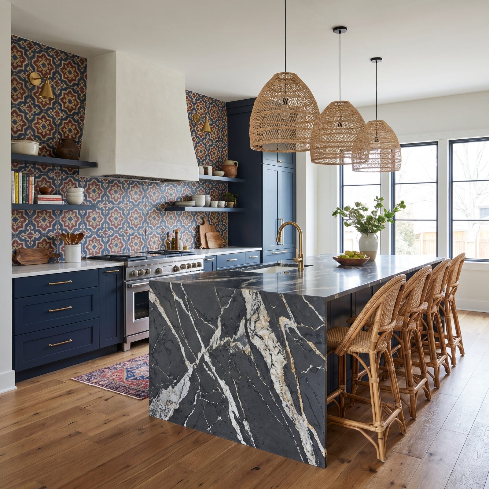 Kitchen with a heavily veined waterfall island in front of a bold patterned tile backsplash.