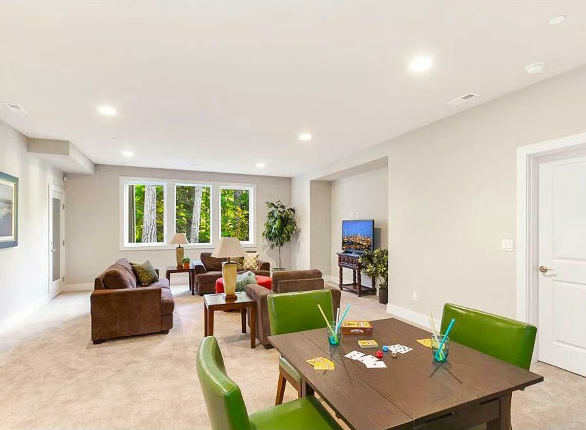 Green Leather Chairs and a Game Table Signal That the Basement Has a Real Purpose