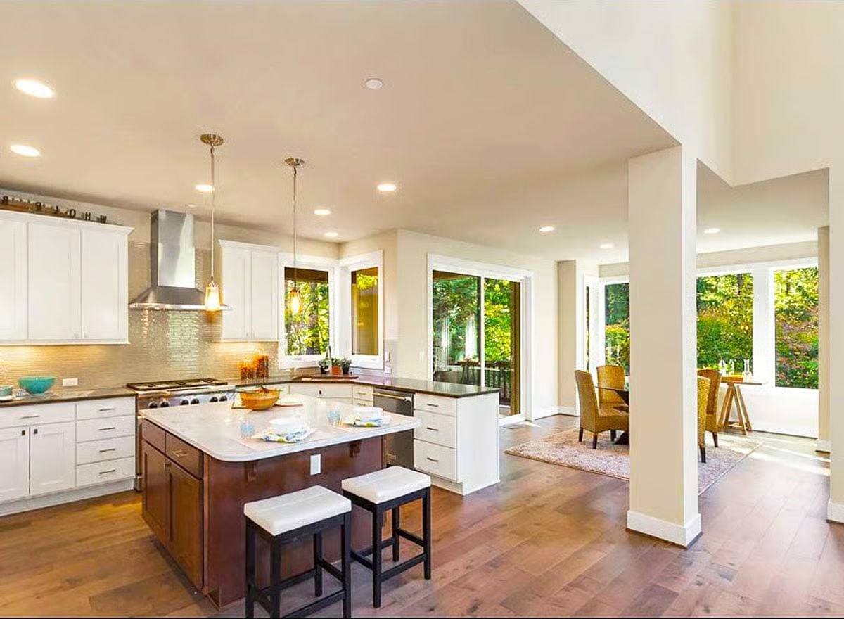 Walnut Island, White Cabinets, and a Wall of Trees Just Beyond the Glass