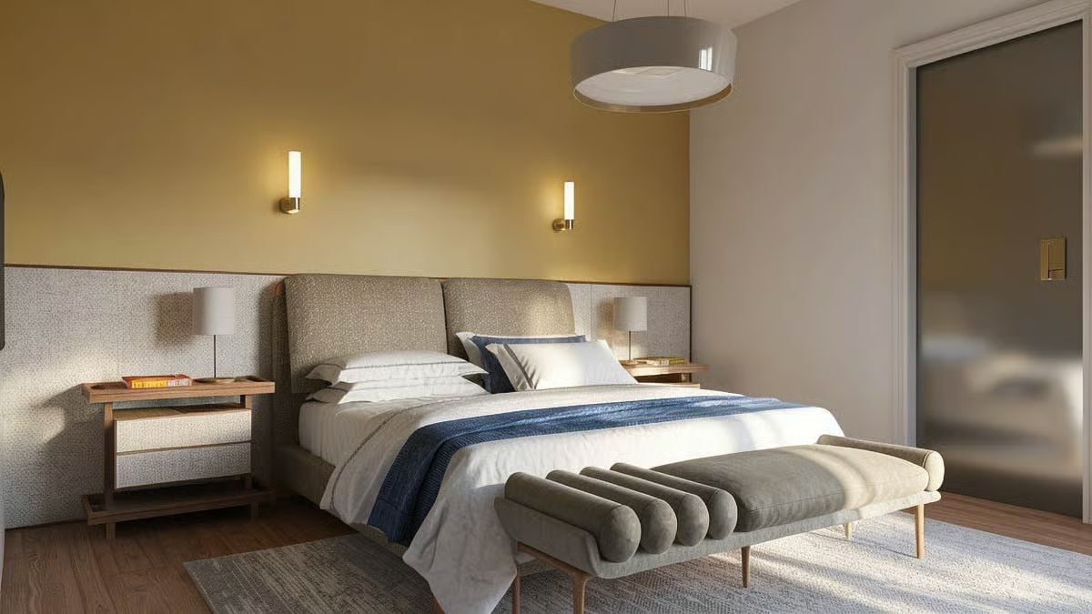 Warm Gold Walls, Brass Sconces, and a Bench That Earns Its Place at the Foot of the Bed