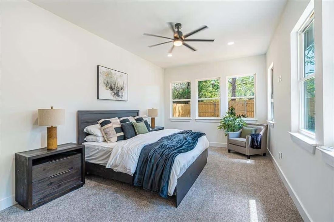 Dark Wood Furniture Against White Walls Keeps a Big Bedroom From Feeling Cold