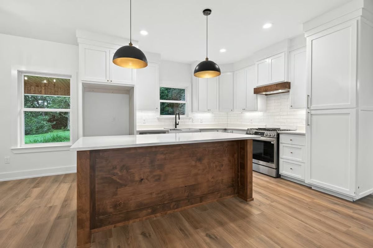 Black Dome Pendants Over a Wood Island That Holds Its Own Against White Cabinets