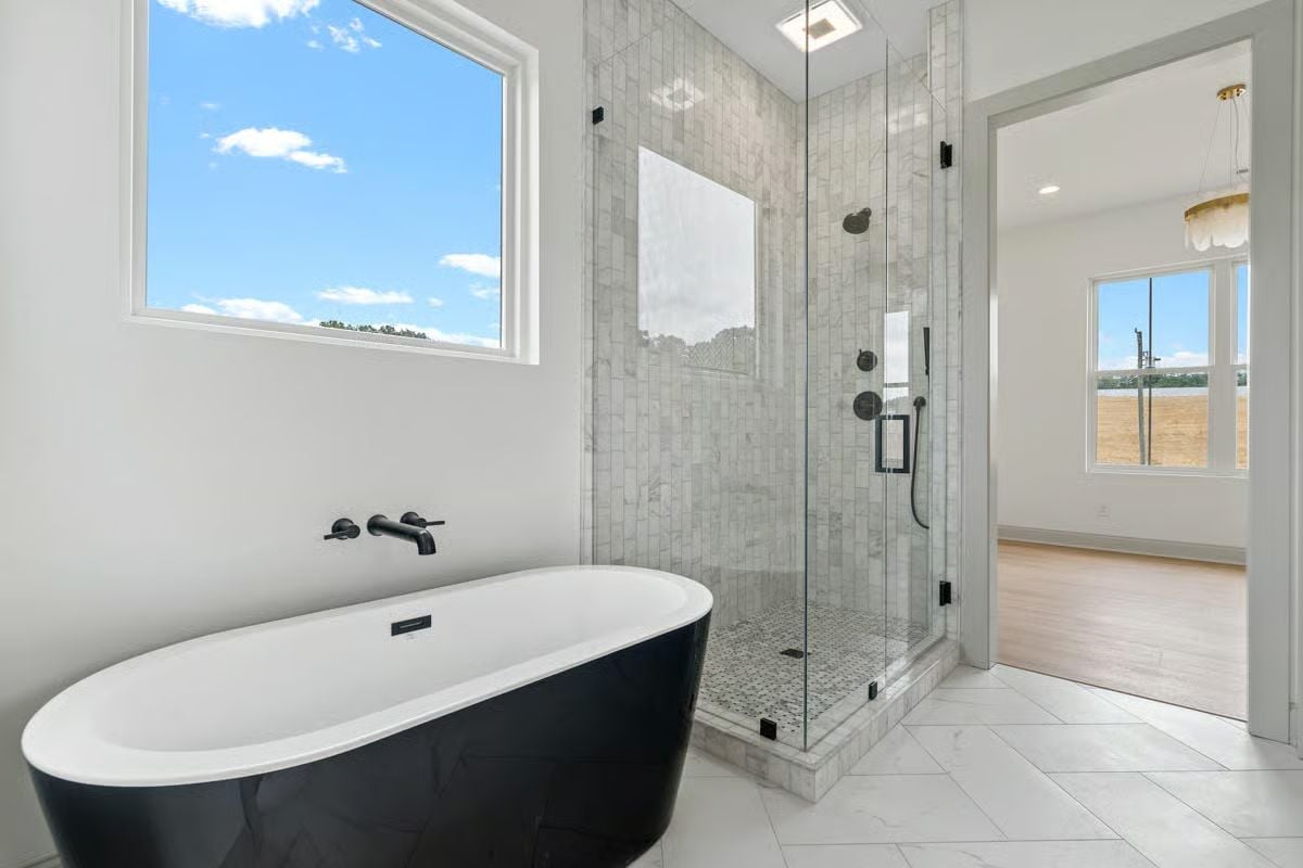 Matte Black Fixtures Against Marble Tile Pull This Primary Bath Into Focus