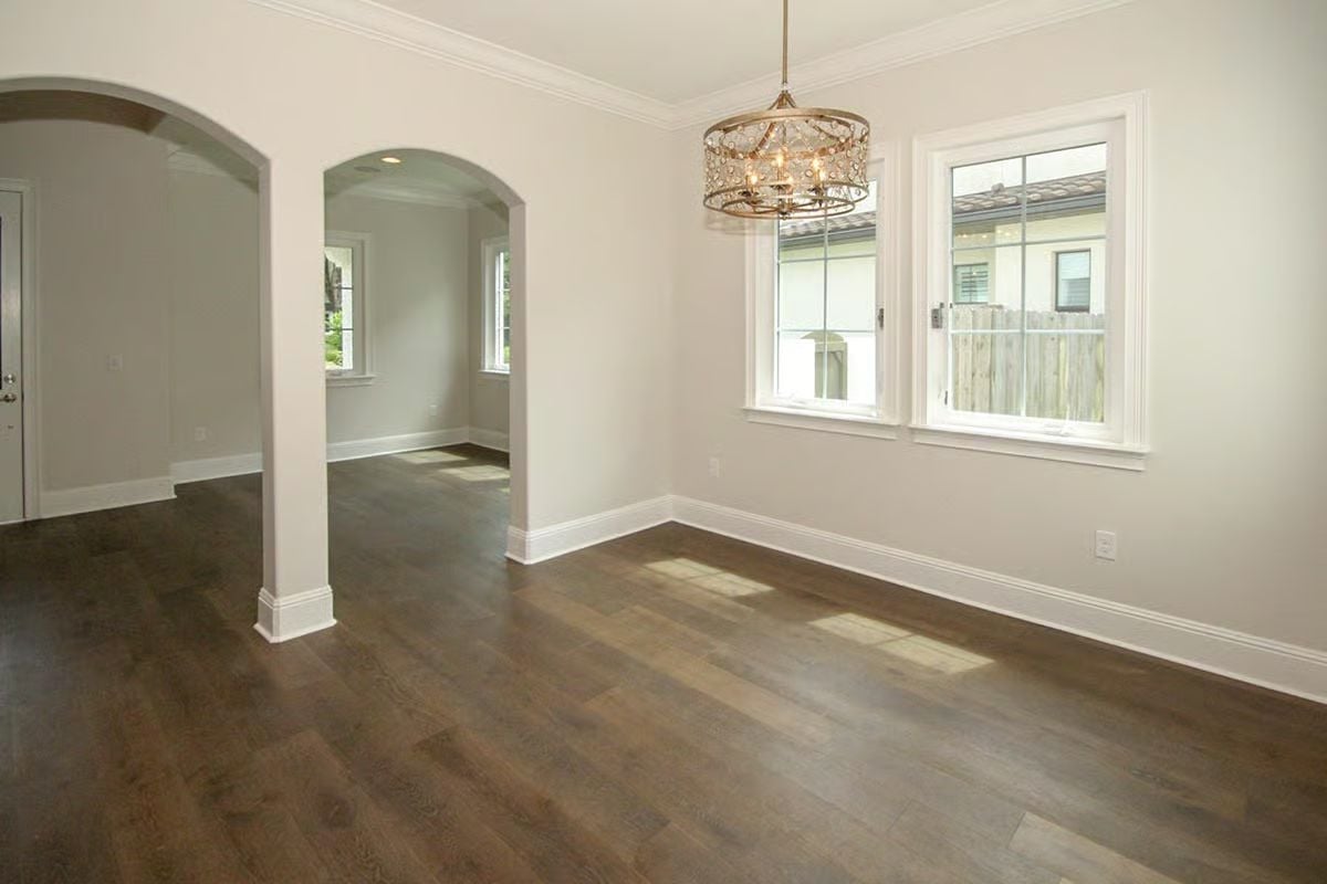 Crystal Chandelier and Arched Doorways Anchor an Empty Room Worth Finishing Slowly