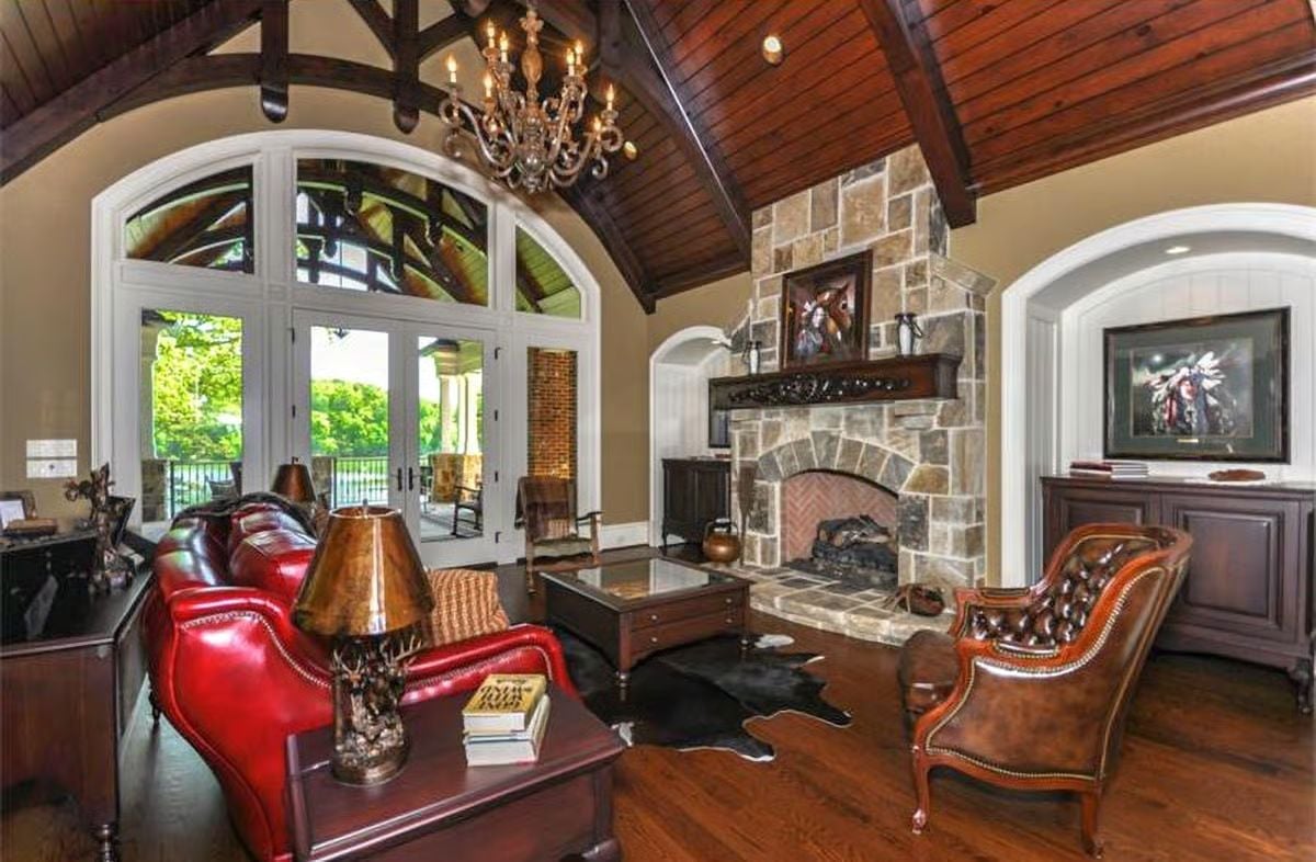 Stone Fireplace, Red Leather, and a Chandelier That Means Business