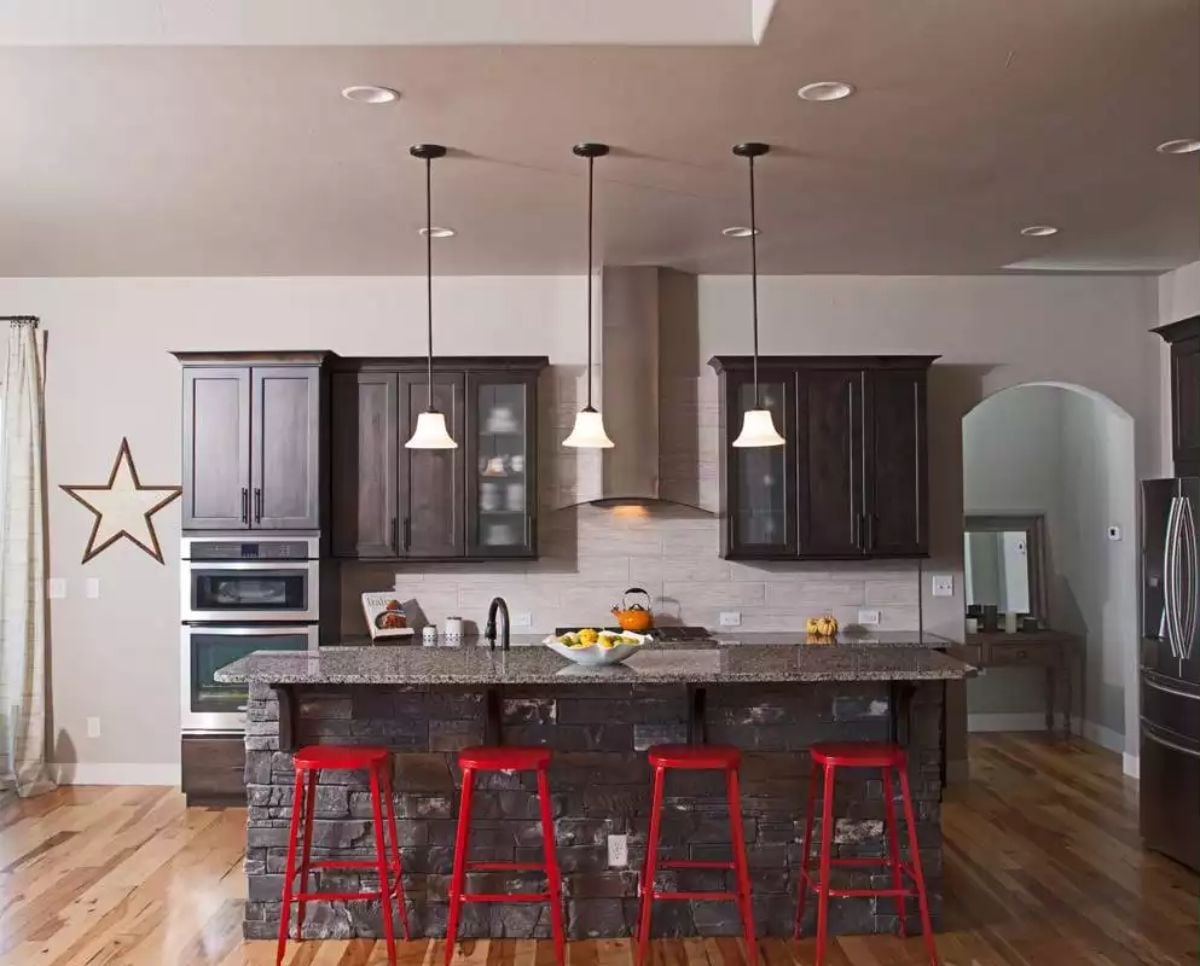 Red Barstools Against Stacked Stone Pull This Kitchen Away From Generic