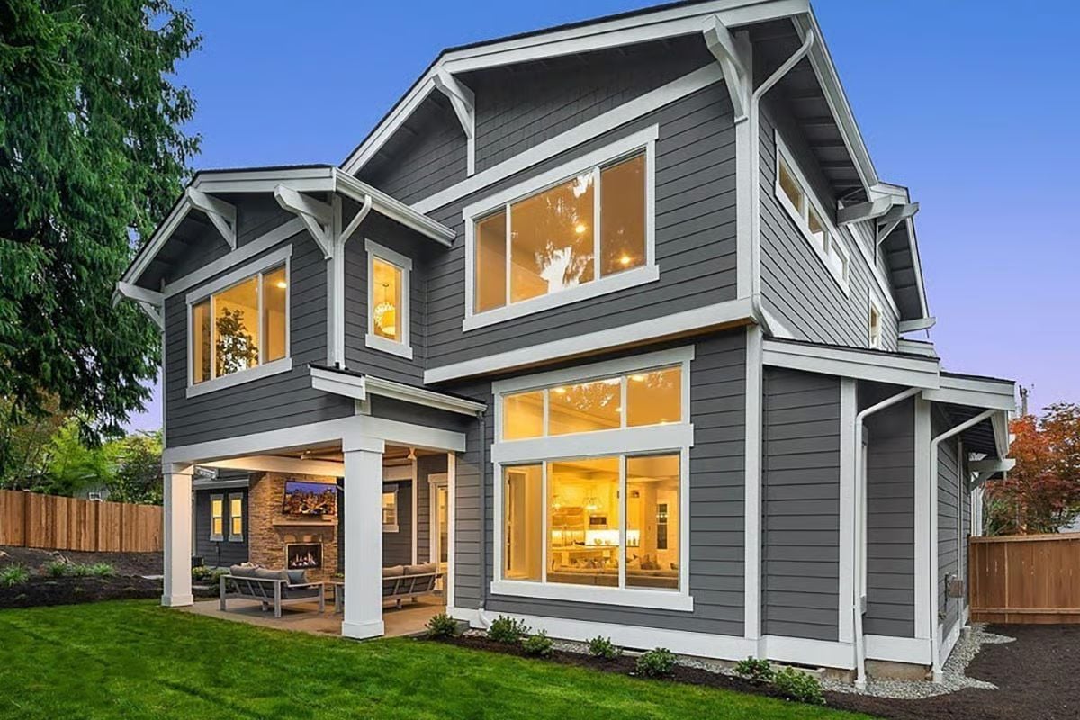 Gray Lap Siding, Glowing Windows, and an Outdoor Room That Pulls Its Weight