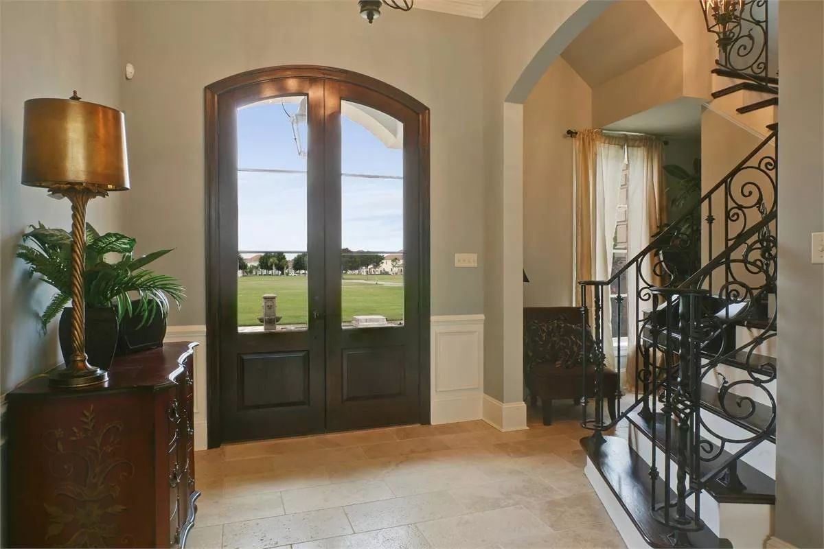 Arched Entry Doors With Wrought Iron Stairs Signal What Kind of House This Is