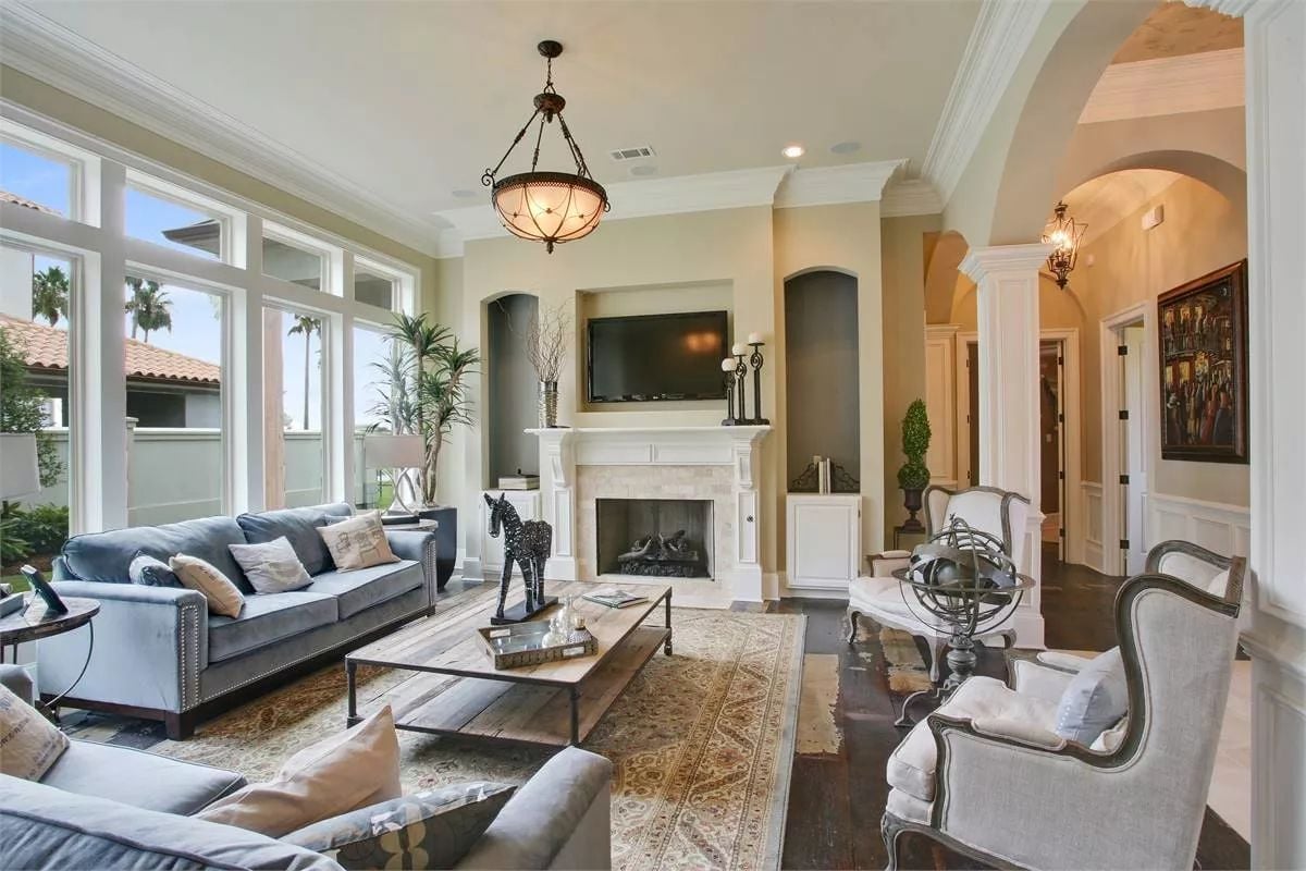 Arched Niches and a White Marble Fireplace Anchor a Living Room Built to Last