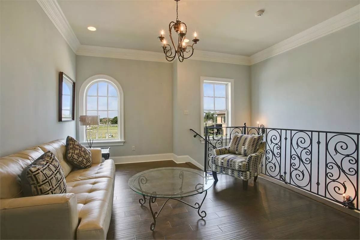 Upstairs Sitting Room With Wrought Iron Railing and an Arched Window Worth Keeping