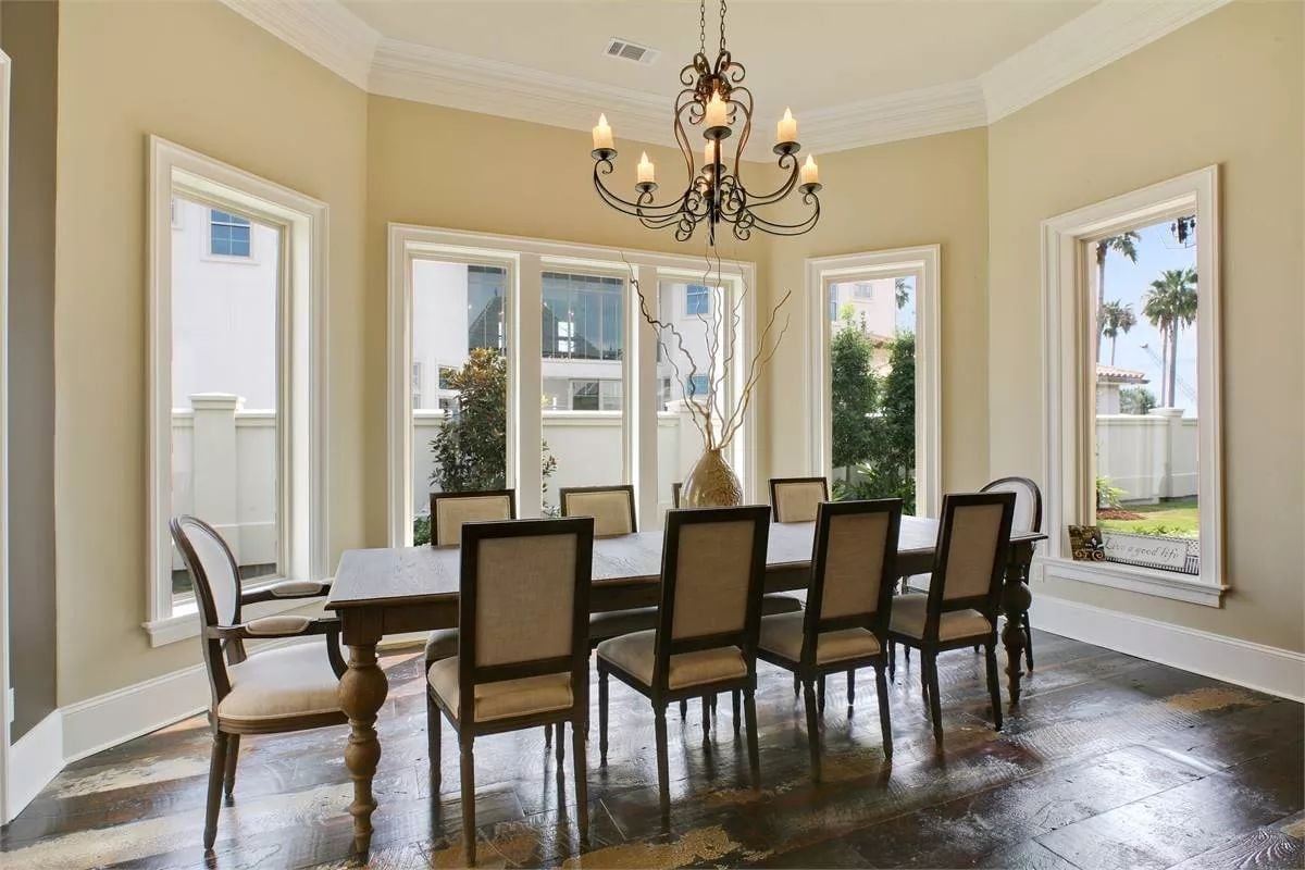 Wrought Iron Chandelier and Dark Herringbone Floors Set the Tone Before Anyone Sits Down