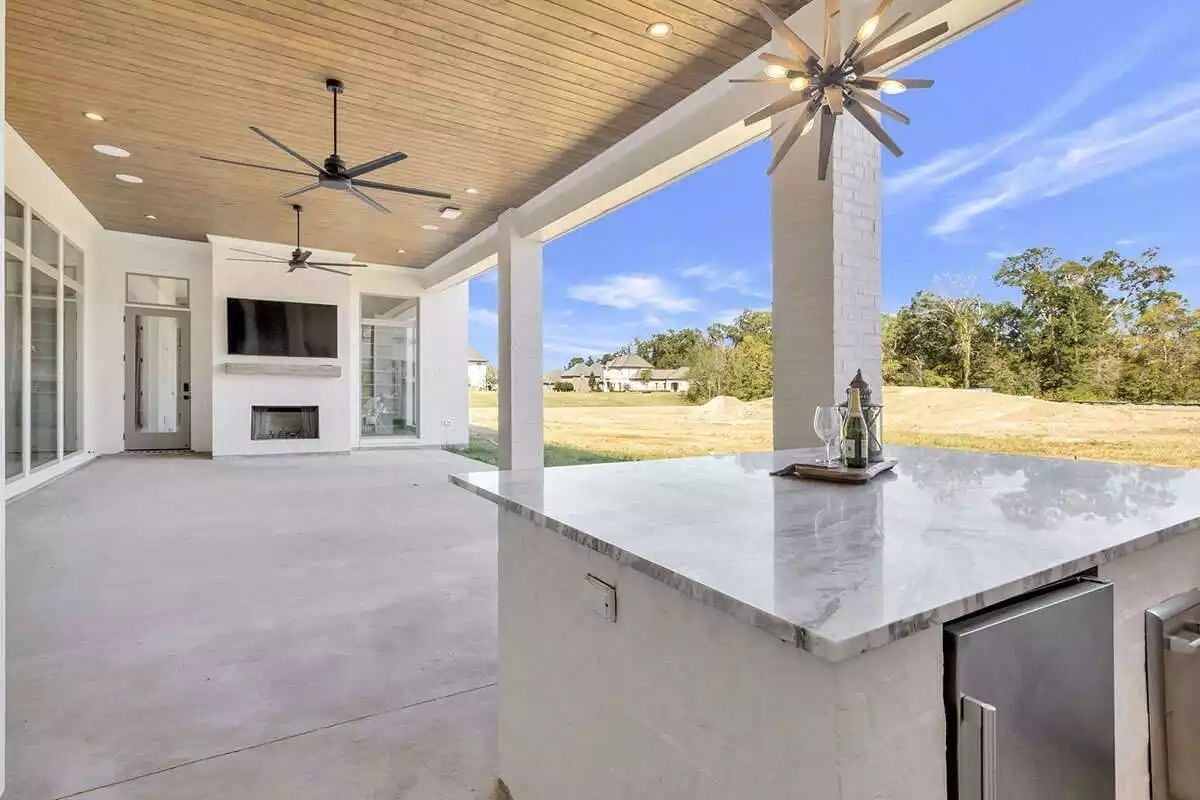 Covered Porch With Marble Bar, Two Fans, and a Fireplace Worth Staying Out For