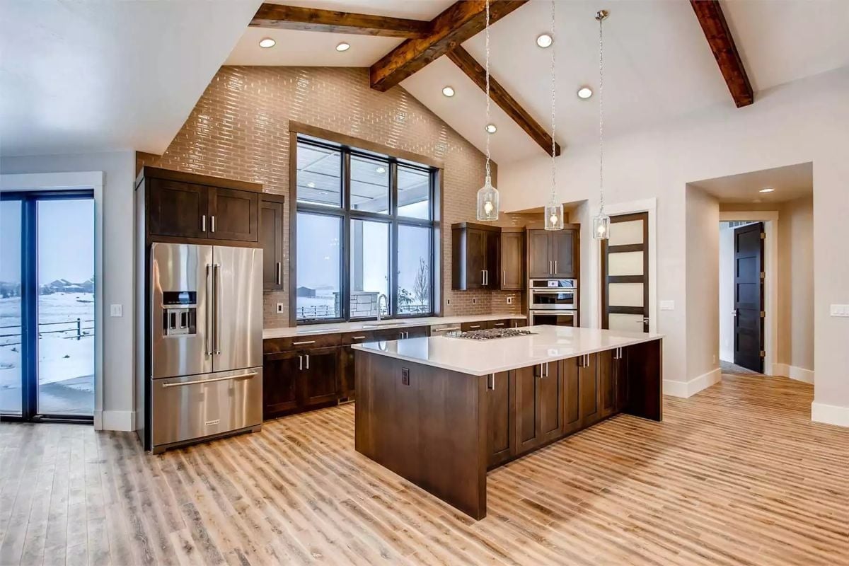 Vaulted Kitchen Where the Brick Wall and Gas Cooktop Island Split the Work