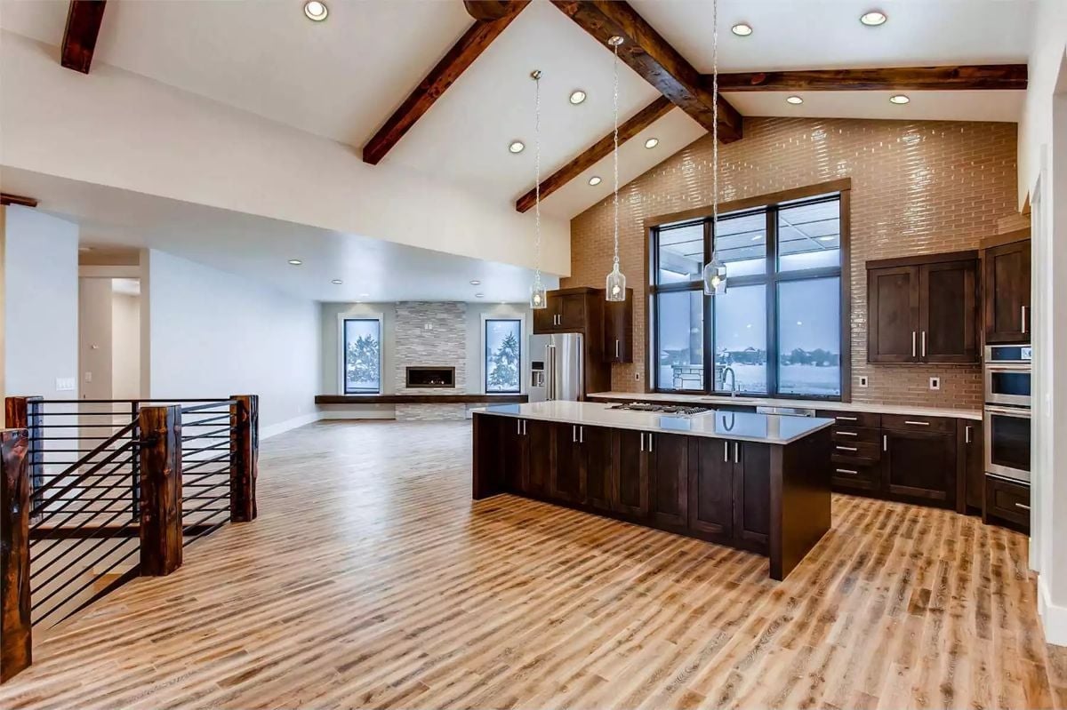 Vaulted Kitchen With Brick Accent Wall and Pendant Lights Worth the Ceiling Height