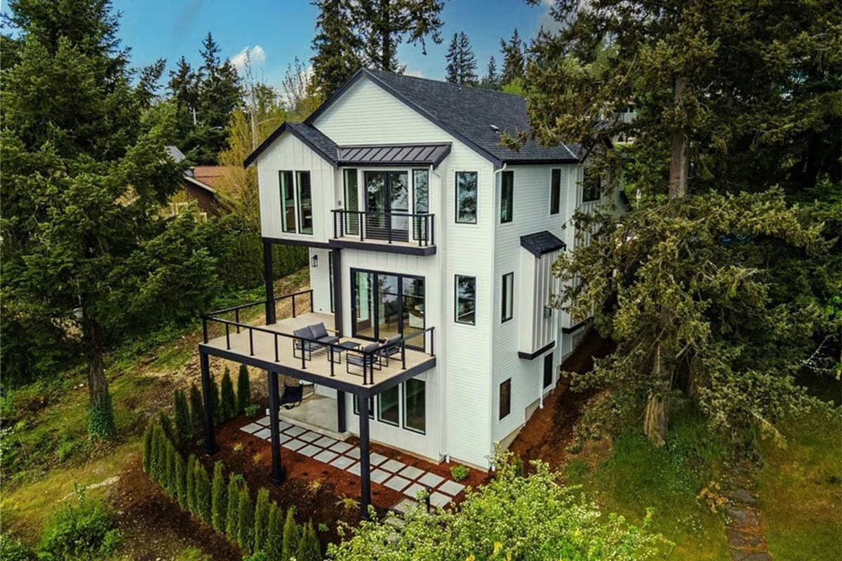 White Siding, Black Trim, and Three Levels of Trees in Every Direction