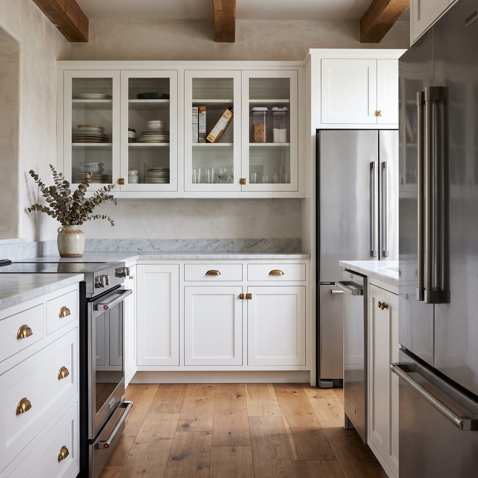 White shaker kitchen with glass-front upper cabinets showing everyday plates, glasses, a cereal box, and containers.