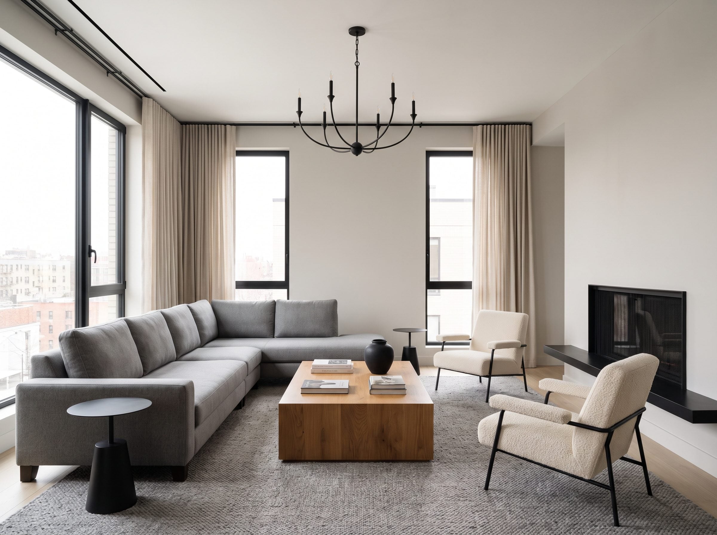 Gray living room with matte-black window frames, floor lamp, fireplace surround and table base making up about one-eighth of