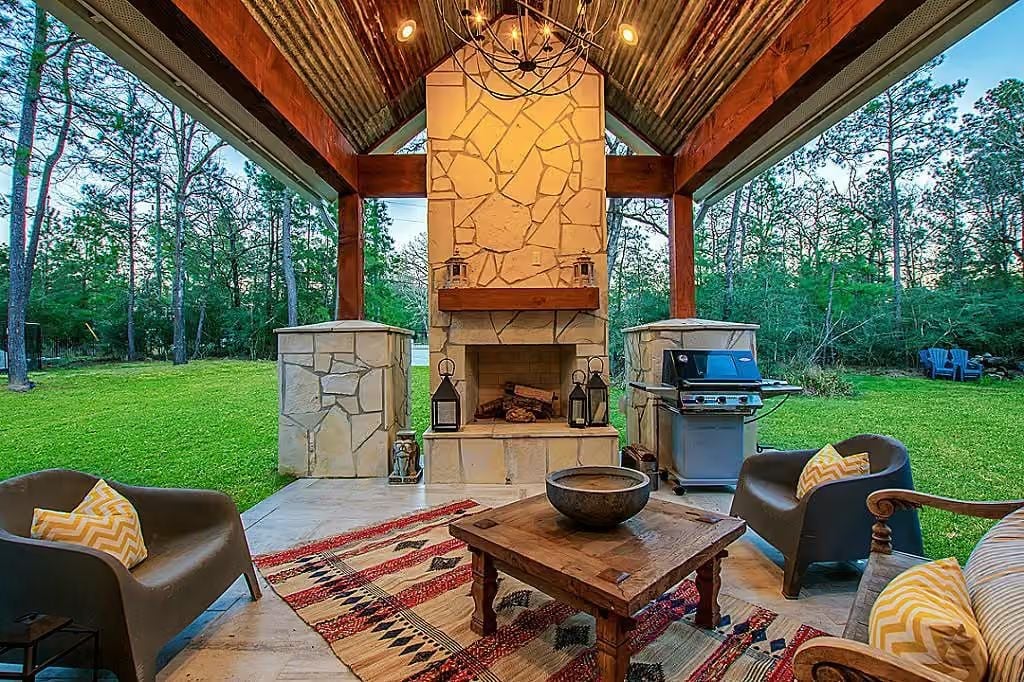 Corrugated Metal Ceiling and Stone Fireplace Make This Outdoor Room Work Year-Round