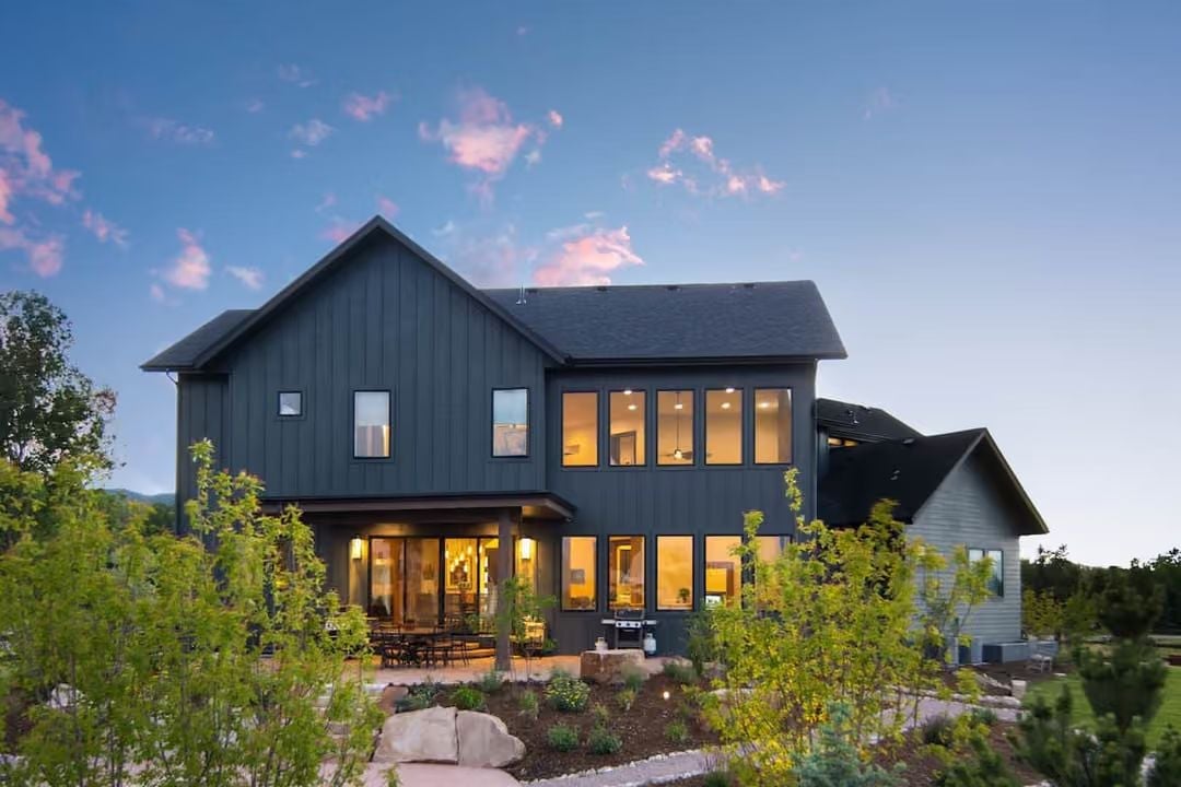 Warm Light Spills Through Two Stories of Glass on a Colorado Dusk
