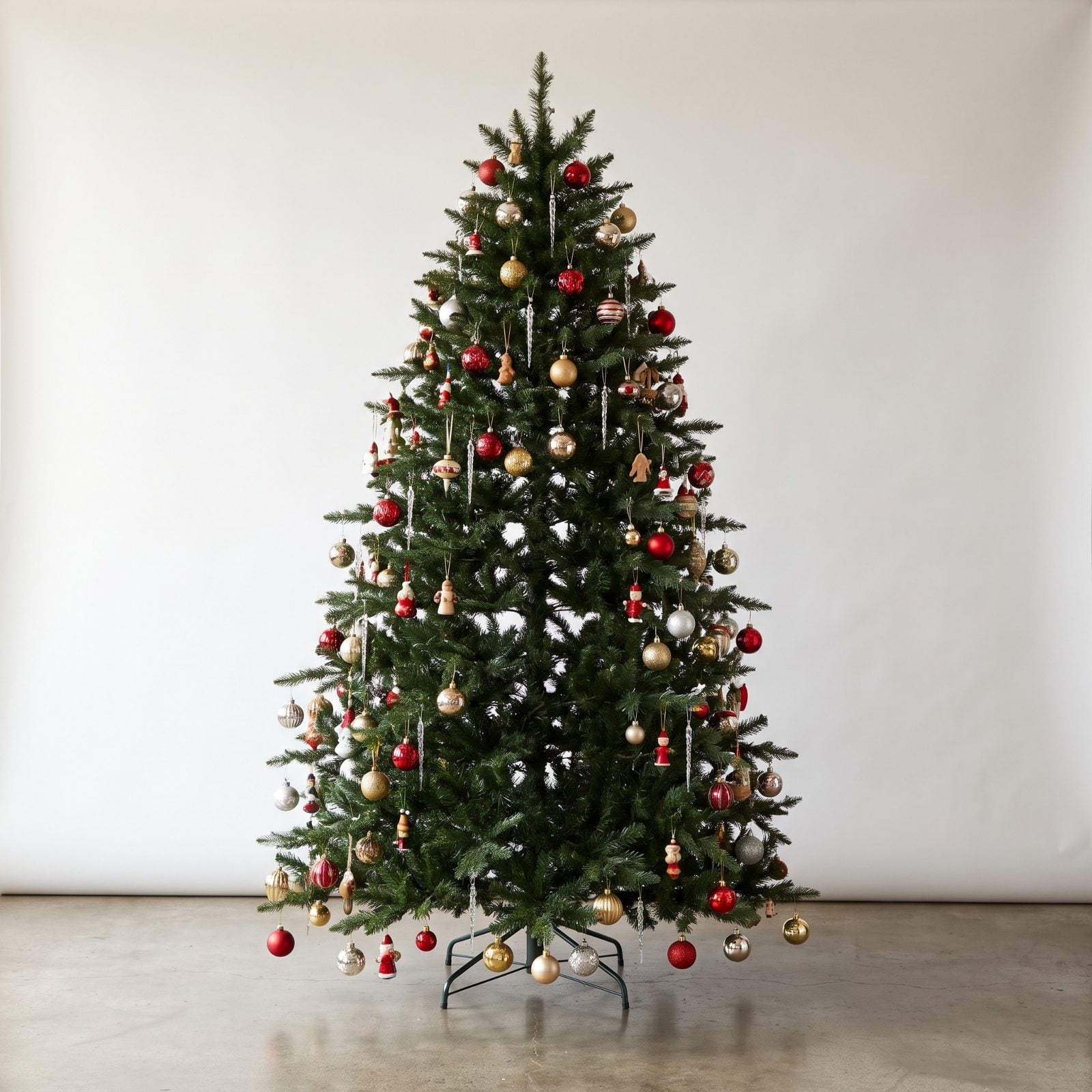 Artificial tree with all ornaments hung on the outer branch tips, leaving the interior empty and flat.