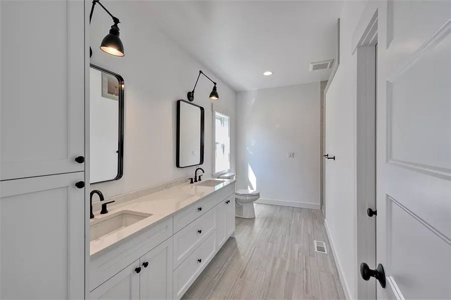 Swing-Arm Sconces and Matte Black Hardware Pull a Double Vanity Together