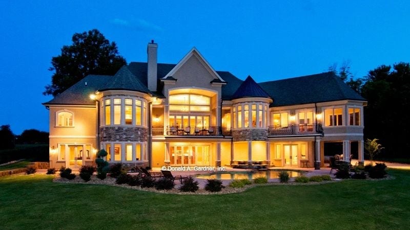 Warm Stone and Glass Light Up the Night on This European Rear Elevation