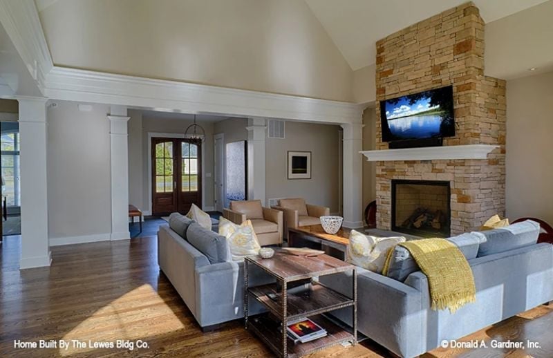 Stone Fireplace, Gray Velvet, and a TV That Doesn't Apologize for Being There
