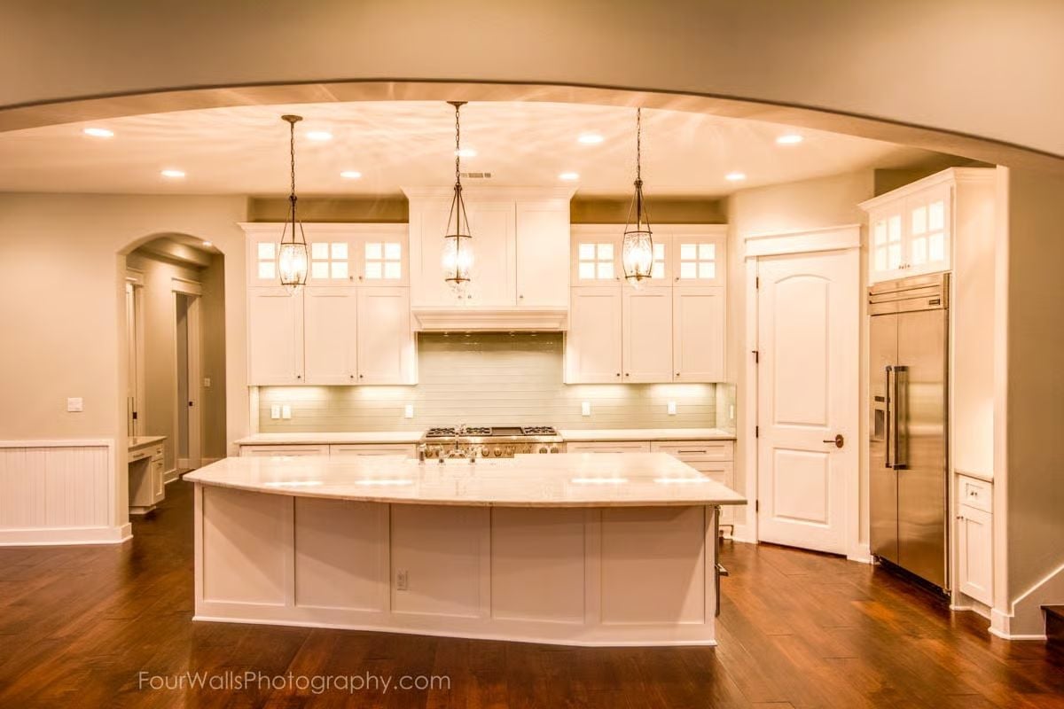 Curved Island, Pendant Trio, and a Stainless Fridge That Doesn't Pretend to Be Anything Else