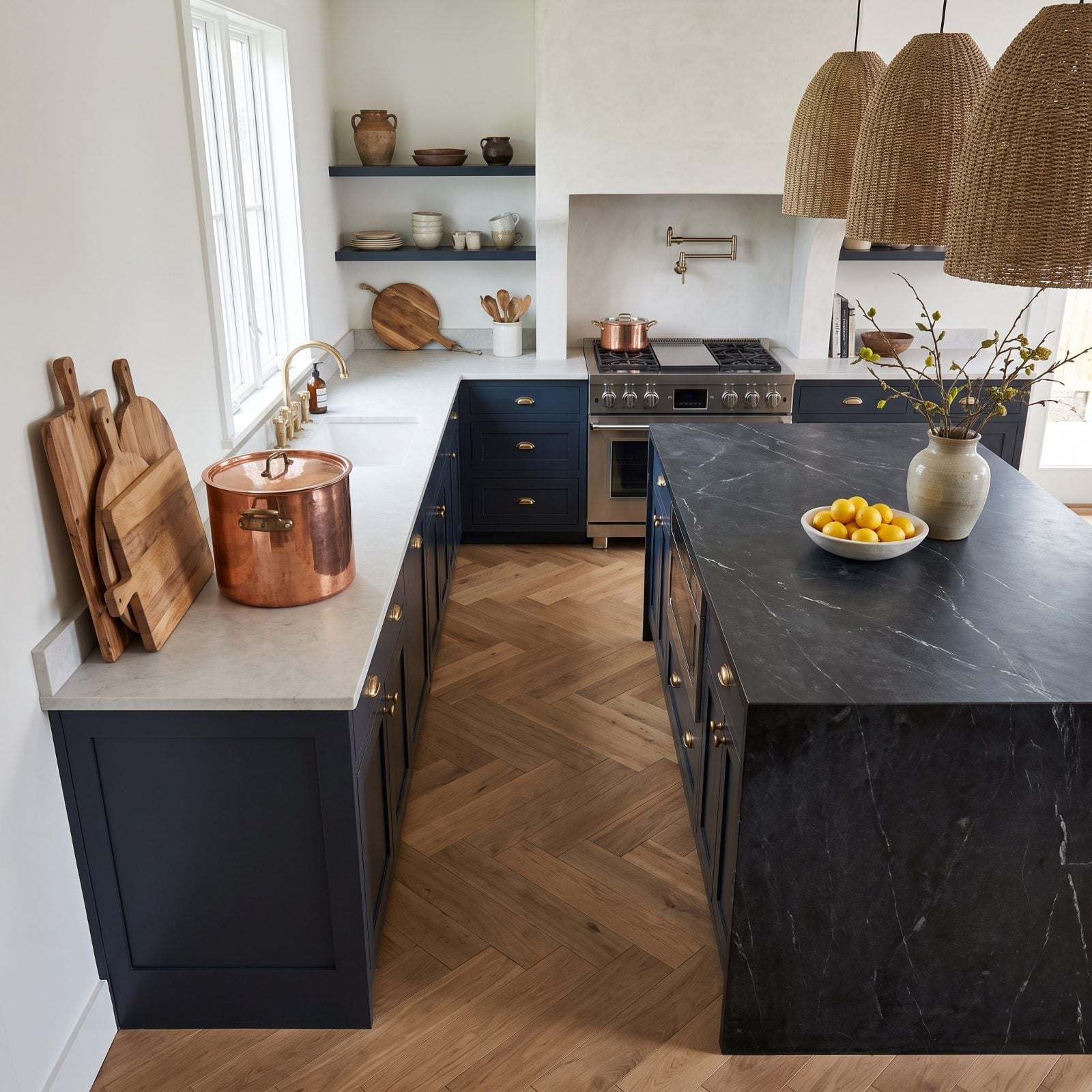 White oak kitchen with a waterfall island set 34 inches from the sink run, narrowing the main work aisle.